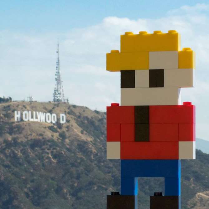 Image of LEGO George traveling the world, in front of the Hollywood sign