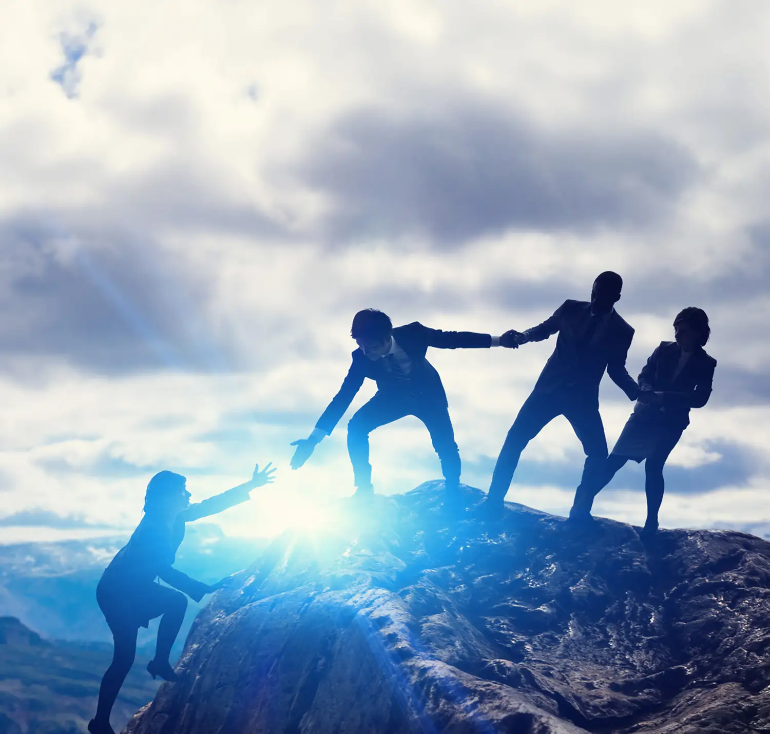 people on a mountain helping each other up
