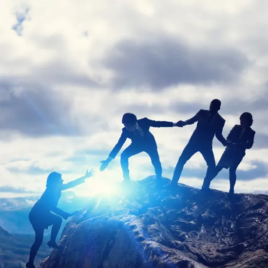 people on a mountain helping each other up