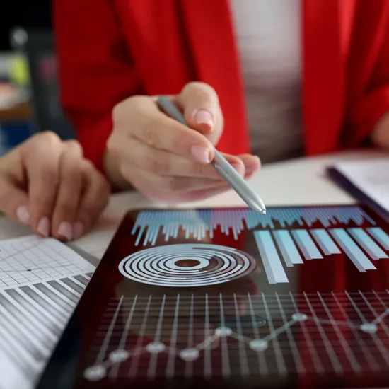 people pointing at a tablet with graphs on it